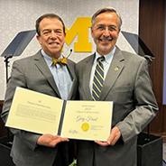 Freed receives the Distinguished Faculty Achievement Award from Domenico Grasso, U-M's interim president.